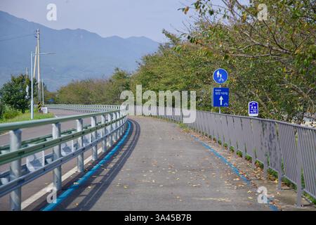 Gwangyang City, Corea del Sud - 3 ottobre 2021: Una vista panoramica del Seomjingang Bike Path con foglie autunnali cadute sparse sul marciapiede, l Foto Stock