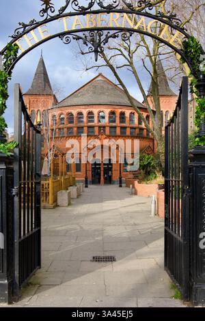 Il Tabernacle, un luogo di arte e intrattenimento a Notting Hill, Londra, visto attraverso cancelli in ferro battuto Foto Stock