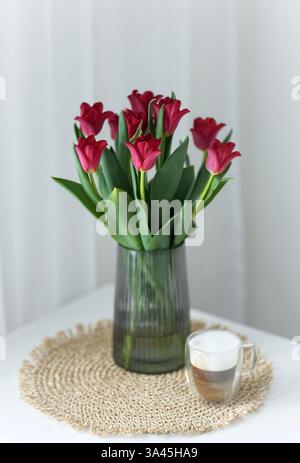 Bouquet di tulipani rossi con una tazza di caffè Foto Stock
