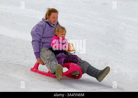 Madre e figlia si divertono con lo slittino nella località sciistica Borovets in Bulgaria. Foto Stock