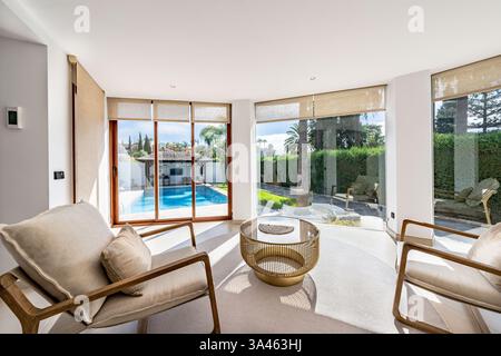 un'immagine di una lussuosa galleria panoramica in villa di lusso con vista sulla piscina privata nel giardino Foto Stock