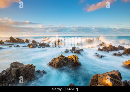 La piscina naturale dell'Oceano Atlantico, Porto Moniz a Madeira, Portogallo, con la costa rocciosa al tramonto con splendidi colori e vista panoramica Foto Stock