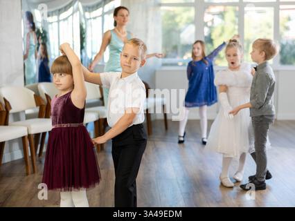 Entusiasti bambini preadolescenti che ballano valzer a coppie nella scuola di danza Foto Stock