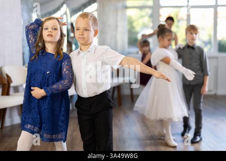 Danze classiche eseguite da bambini preadolescenti in abiti festivi Foto Stock