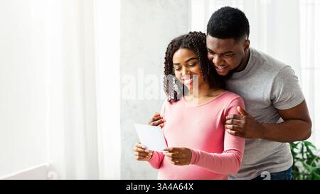 Donna incinta e suo marito che guarda l'immagine Foto Stock