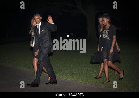 31 agosto 2014 - Washington, District of Columbia, Stati Uniti d'America - il presidente degli Stati Uniti Barack Obama salta alle telecamere mentre lui e la prima Family Walk verso la Casa Bianca dopo aver sbarcato Marine One sul South Lawn della Casa Bianca a Washington, District of Columbia, USA, domenica 31 agosto, 2014. la prima famiglia si è recata a Westchester County, New York, per partecipare al matrimonio di un consulente politico senior per la politica nutrizionale e trasferiamo il direttore esecutivo, Sam Kass, al presentatore dell'MSNBC Alex Wagner. Da sinistra a destra: Malia Obama, presidente Obama, first lady Michelle Obama Foto Stock