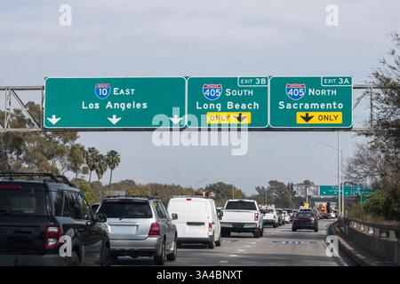 Il traffico è lento e passa sotto le indicazioni della superstrada Santa Monica 10 allo svincolo di San Diego 405 a Los Angeles. Foto Stock