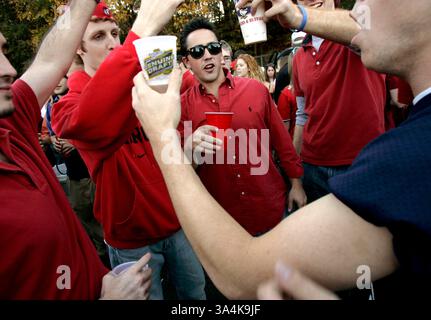 12 novembre 2005; Athens, Georgia, USA; Andrew Gomez (centro), ex allievo dell'Università della Georgia, e gli amici urlano per i Bulldogs durante una festa in un parcheggio fuori East Campus Road ore prima della partita di football tra l'Università della Georgia e l'Università di Auburn ad Athens, GA, sabato 12 novembre 2005. Gomez ha detto che ha iniziato una festa regolare in questo posto sei anni fa quando era una matricola ed è diventata una tradizione in ogni partita in casa. C'erano 14 fusti di birra alla festa di sabato, ha detto Gomez. Credito obbligatorio: Foto di Allen Sullivan/ZUMA Press. (©) Copyright 2005 di Allen Sullivan Foto Stock