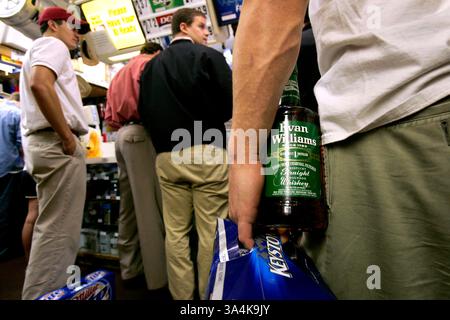 12 novembre 2005; Athens, Georgia, USA; Nick Kelley (tenendo la bottiglia a destra), un senior laureato in immobiliare dell'Università della Georgia, attende in fila per acquistare alcolici presso il negozio di bottiglie Five Points di Atene, GA, sabato 12 novembre 2005. Kelley ha detto che avrebbe iniziato a bere con gli amici intorno alle 14 del sabato, diverse ore prima del calcio d'inizio nella partita di football casalingo tra l'Università della Georgia e l'Università di Auburn. Devi imparare a stare al passo. In questo modo puoi andare tutto il giorno", ha detto Kelley. Credito obbligatorio: Foto di Allen Sullivan/ZUMA Press. (©) Copyright 2005 di Allen Sullivan Foto Stock