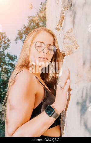 Donna occhiali albero Ritratto - giovane donna che indossa occhiali si appoggia contro un albero in un ritratto. Foto Stock
