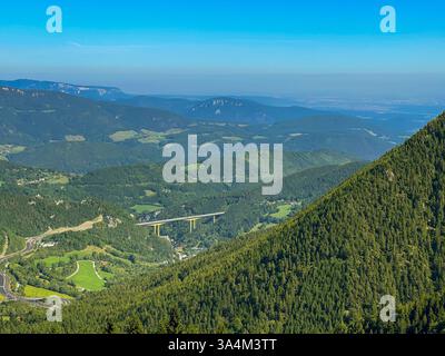 Vista di una valle alpina di montagna alla luce del giorno dalla cima di una montagna Foto Stock