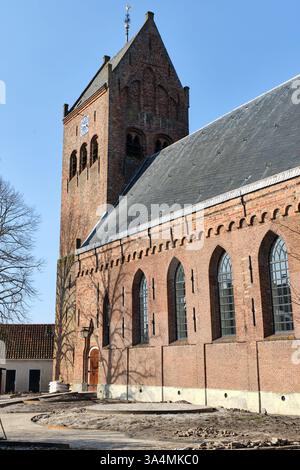 10 marzo 2025 - Grou-Paesi Bassi: Vecchia chiesa con campanile della storica Grou, Frisia, caratterizzata da una struttura in mattoni, tetto a sella, finestre ad arco e Foto Stock