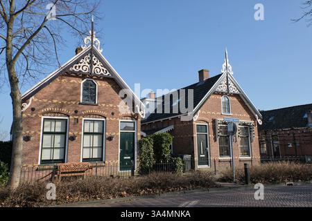 10 marzo 2025 - Grou, Paesi Bassi: Una fila di case dei lavoratori dei primi anni del XX secolo, parte della prima casa sociale del villaggio. Queste case di mattoni fe Foto Stock