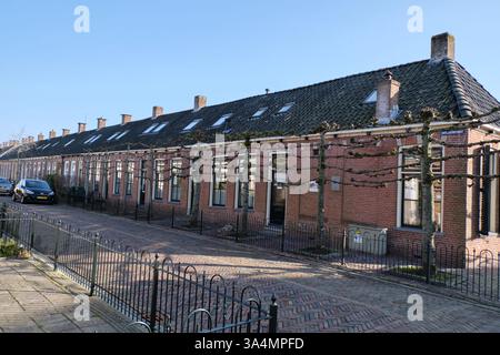 10 marzo 2025 - Grou, Paesi Bassi: Una fila di case dei lavoratori dei primi anni del XX secolo, parte della prima casa sociale del villaggio. Queste case di mattoni fe Foto Stock