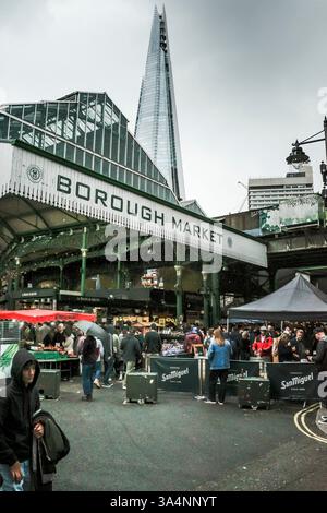 Persone che visitano lo storico Borough Market di Southwark a Lonon con l'iconico Shard sullo sfondo nel Regno Unito in Europa. Foto Stock