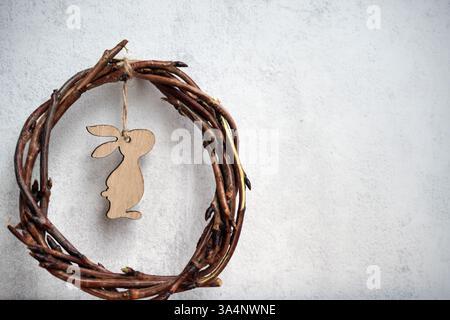 corona pasquale di rami di viti con filetto su sfondo grigio con copyspace. Foto Stock