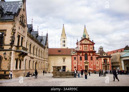 Basilica di San Giorgio a Praga, con la sua facciata romanica e gli edifici storici circostanti all'interno del complesso del Castello di Praga. Foto Stock
