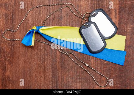 Distintivi dell'esercito e bandiera Ucraina su sfondo di legno Foto Stock