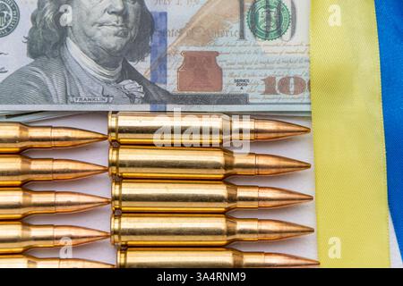 Dollari americani, bandiera Ucraina e cartucce di fucili su sfondo chiaro Foto Stock