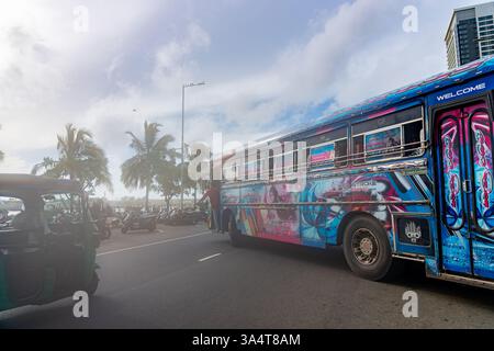 Colombo Sri Lanka - 2 settembre 2024; autobus tipicamente colorato che gira su Galle Road con nebbia di mare o foschia dalla costa sopra Galle Face Green. Foto Stock
