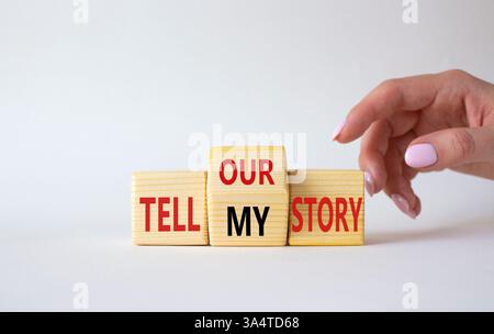 Raccontate il nostro simbolo o la mia storia. L'uomo d'affari punta i cubi di legno con parole che raccontano la mia storia e raccontano la nostra storia. Splendido sfondo bianco. Affari Foto Stock