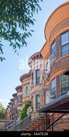 Una fila di case di due famiglie in mattoni e terracotta sulla 58th Street a Sunset Park, Brooklyn, con caratteristiche facciate bulbose e alte cime. Foto Stock