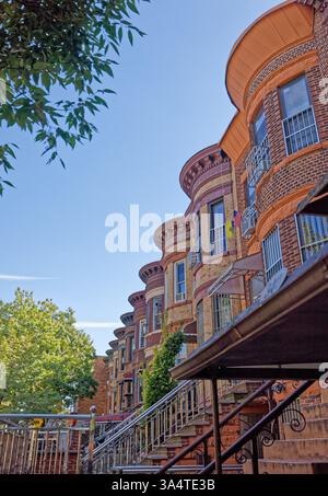 Una fila di case di due famiglie in mattoni e terracotta sulla 58th Street a Sunset Park, Brooklyn, con caratteristiche facciate bulbose e alte cime. Foto Stock