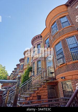 Una fila di case di due famiglie in mattoni e terracotta sulla 58th Street a Sunset Park, Brooklyn, con caratteristiche facciate bulbose e alte cime. Foto Stock
