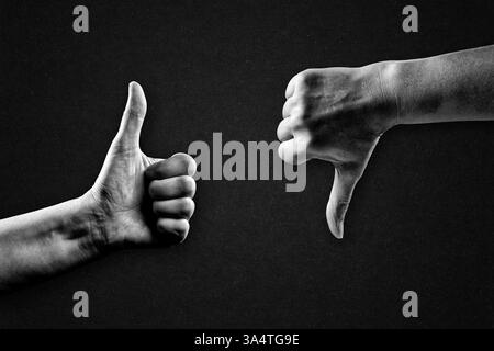 Mano che mostra il pollice su e giù segno in bianco e nero su sfondo carta testurizzata, spazio copia Foto Stock