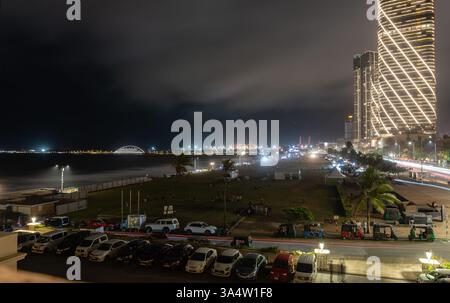 Colombo Sri Lanka - 1 settembre 2024; lunga esposizione notturna su Galle Face Green, auto parcheggiate e moderno edificio commerciale a distanza Foto Stock