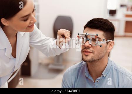 Optometrista che esegue un esame oculistico con un paziente in un ambiente clinico Foto Stock