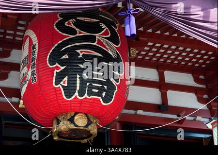 Gigante lanterna rossa di carta chochin appesa nell'Hondo (sala principale) del tempio buddista Sensoji ad Asakusa, Tokyo, Giappone. Foto Stock
