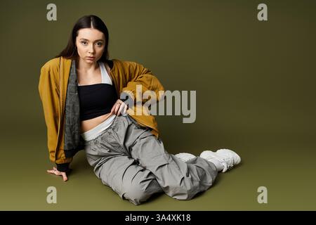 La giovane donna elegante trasuda fiducia in un abbigliamento casual chic con un'atmosfera urbana. Foto Stock