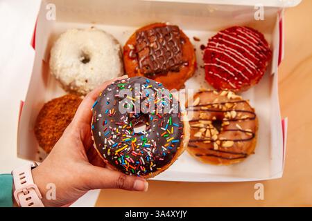 Scatola di ciambelle miste assortite di ciambelle alla brioche fatte a mano. Foto Stock