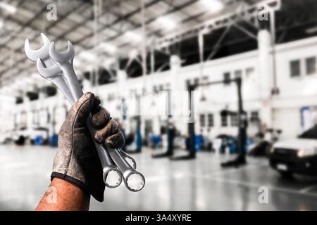 Chiave meccanica in officina automobilistica , chiave a forchetta sottile in mano meccanica , concetto di riparazione automobilistica Foto Stock