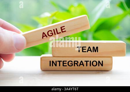 Testo Agile Team Integration su blocco di legno con sfondo naturale sfocato. Concetto di collaborazione e lavoro di squadra. Foto Stock