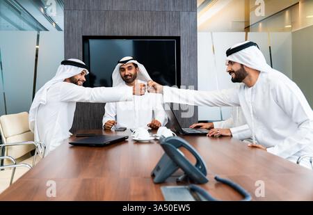 Gruppo di uomini d'affari arabi aziendali che si incontrano in ufficio - uomini d'affari del Medio Oriente che indossano kandora degli emirati che lavorano in una sala riunioni, Dubai Foto Stock