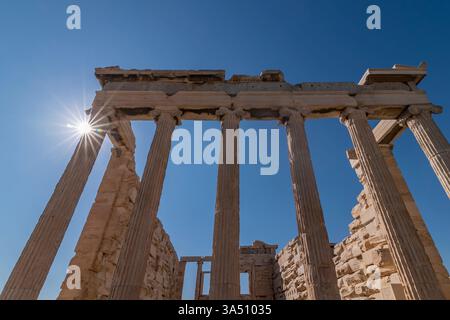 Il sole sbircia sull'Eretteo, un tempio ionico greco del V secolo a.C. situato sull'Acropoli di Atene, in Grecia Foto Stock