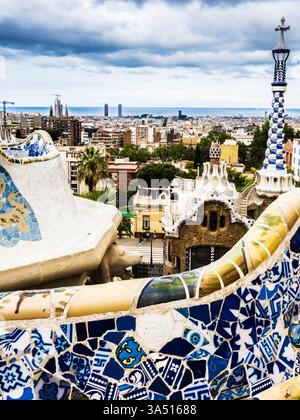 Vista su Barcellona da Piazza natura o Plaza de la natura nel Parc Güell, Barcellona. L'iconica panca piastrellata è in primo piano e la Sagrada Fami Foto Stock