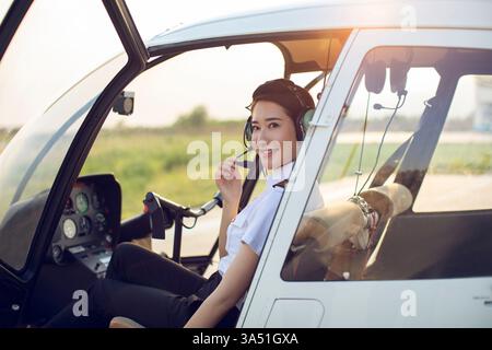 Pilota cinese seduto in elicottero Foto Stock