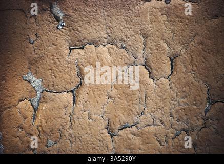Primo piano di strati di intonaco e vernice spelati su una parete di cemento Foto Stock