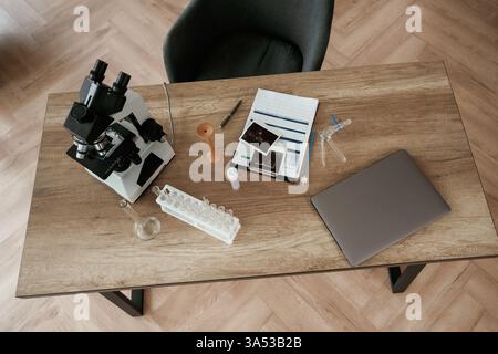 Microscopio e computer portatile. Attrezzature del medico, oggetti sul tavolo. Foto Stock