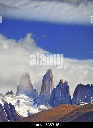 L'armonia primitiva del parco nazionale Torres del Paine. Tre delle famose rocce circondate da pittoresche nuvole Foto Stock