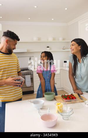 Cucina in famiglia, sorridendo e preparando Macedonia di frutta fresca Foto Stock