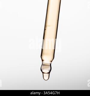 Pipettare con siero, gel, olio o altro prodotto cosmetico su sfondo bianco. Foto Stock