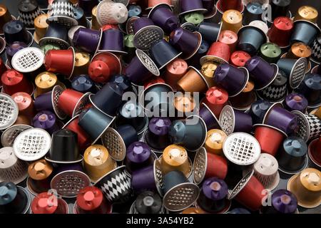 Una grande pila di capsule di caffè colorate in alluminio usate. Concetto di riciclaggio, consumo e sostenibilità nell'uso di caffè monodose. Foto Stock