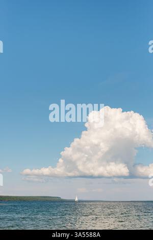 Grande nuvola di tuono sulla barca a vela in acqua con vista sulla scarpata Foto Stock