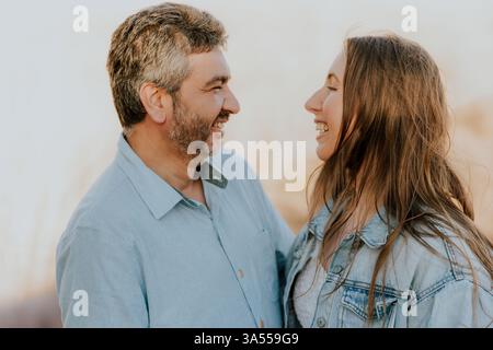 Una coppia amorevole sta vicino, sorridendo in un paesaggio naturale Foto Stock