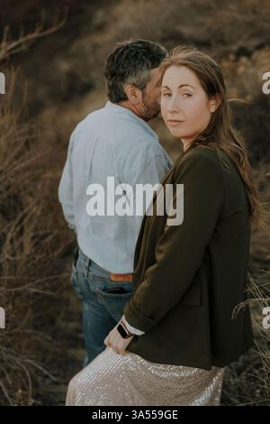 Una donna guarda in alto mentre cammina con un uomo in natura Foto Stock