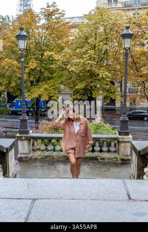 Donna che sale le scale vicino alla Torre Eiffel a Parigi Foto Stock